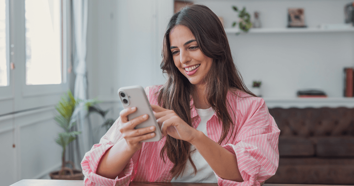 Guest messaging an AI concierge on their phone at a rental dining table