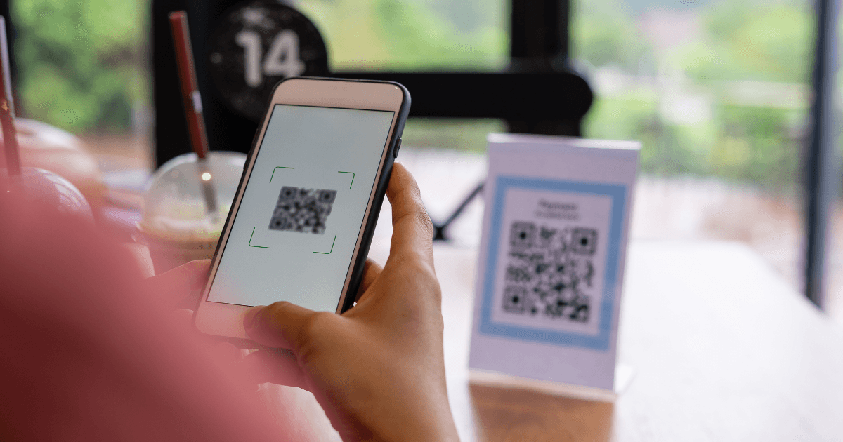 Guest with luggage scanning a QR code inside a bright vacation rental entryway